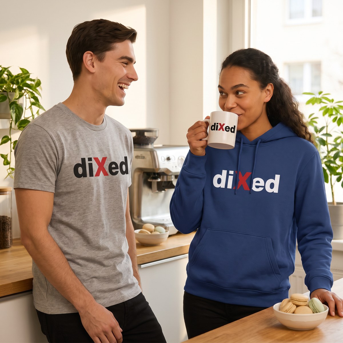 Kaffeepause in der Büroküche: sie trinkt aus einer diXed-Tasse und trägt den blauen diXed-Hoodie, er lacht im grauen diXed-Shirt