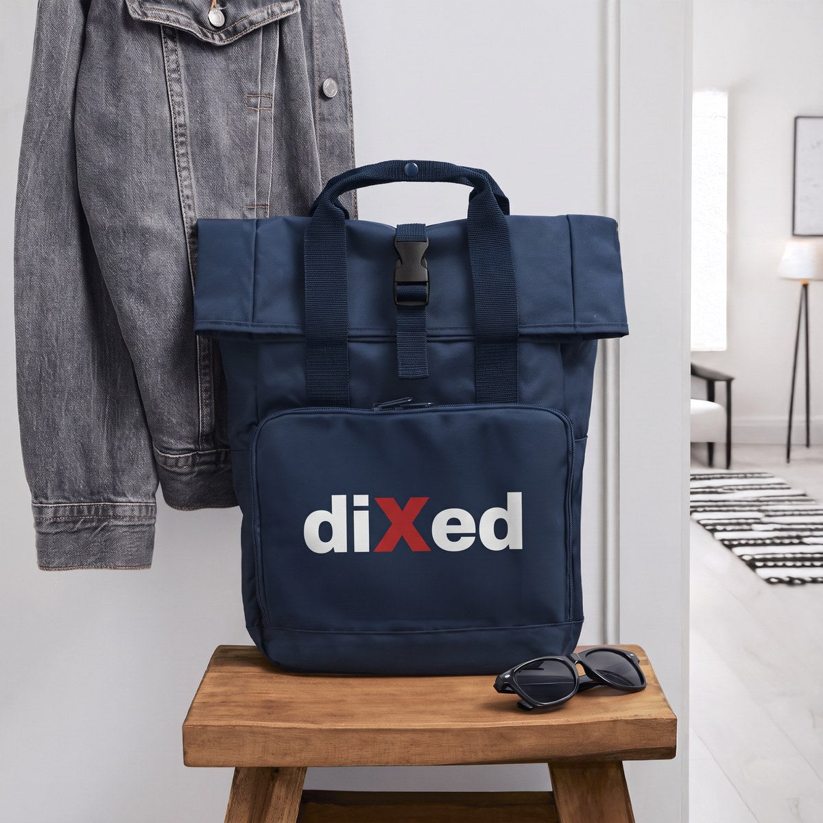 Navyblauer Rolltop-Rucksack mit diXed-Logo auf einem Holzhocker