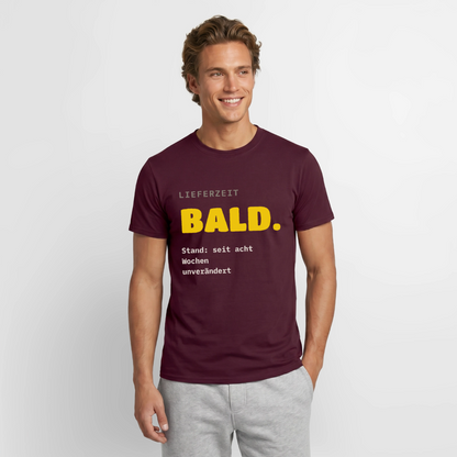 "Lieferzeit: bald. Stand: seit acht Wochen unverändert." Motiv-T-Shirt für Männer, Farbe Ziegelrot