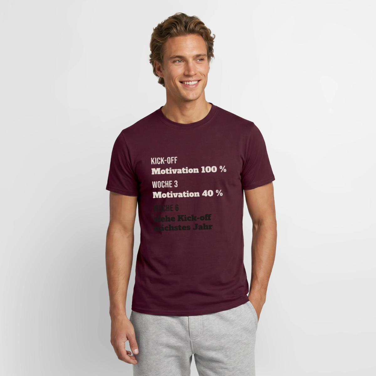 "Kick-off: Motivation 100 %. Woche 3: 40 %. Woche 6: siehe Kick-off nächstes Jahr" Motiv-T-Shirt für Männer, Farbe Ziegelrot