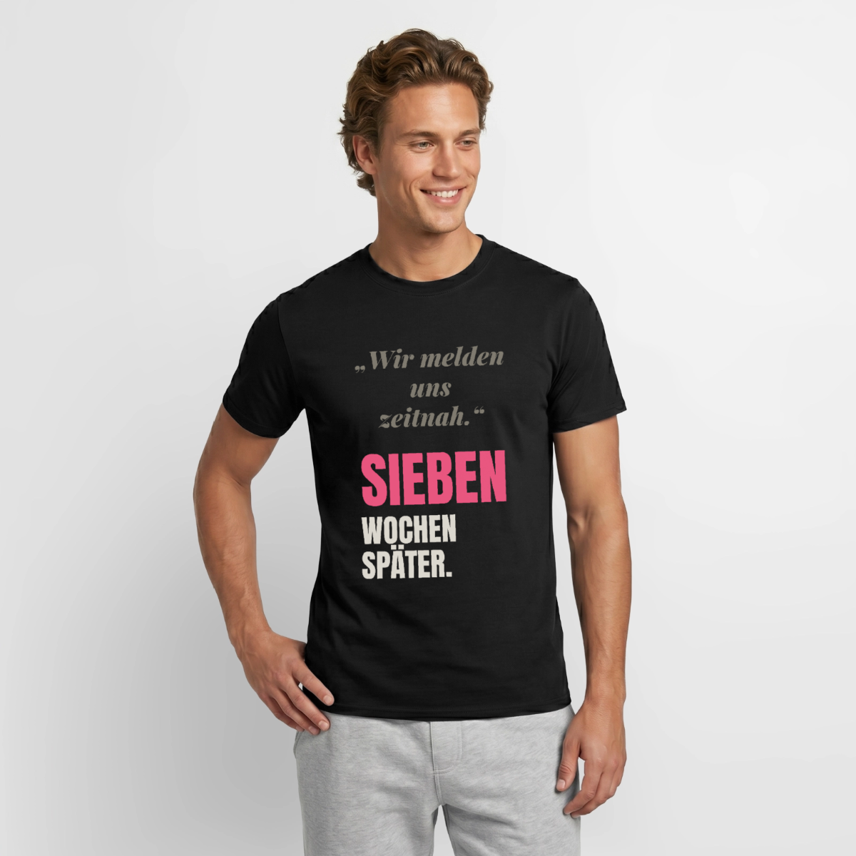 "Wir melden uns zeitnah. Sieben Wochen später." Motiv-T-Shirt für Männer, Farbe Schwarz, Model