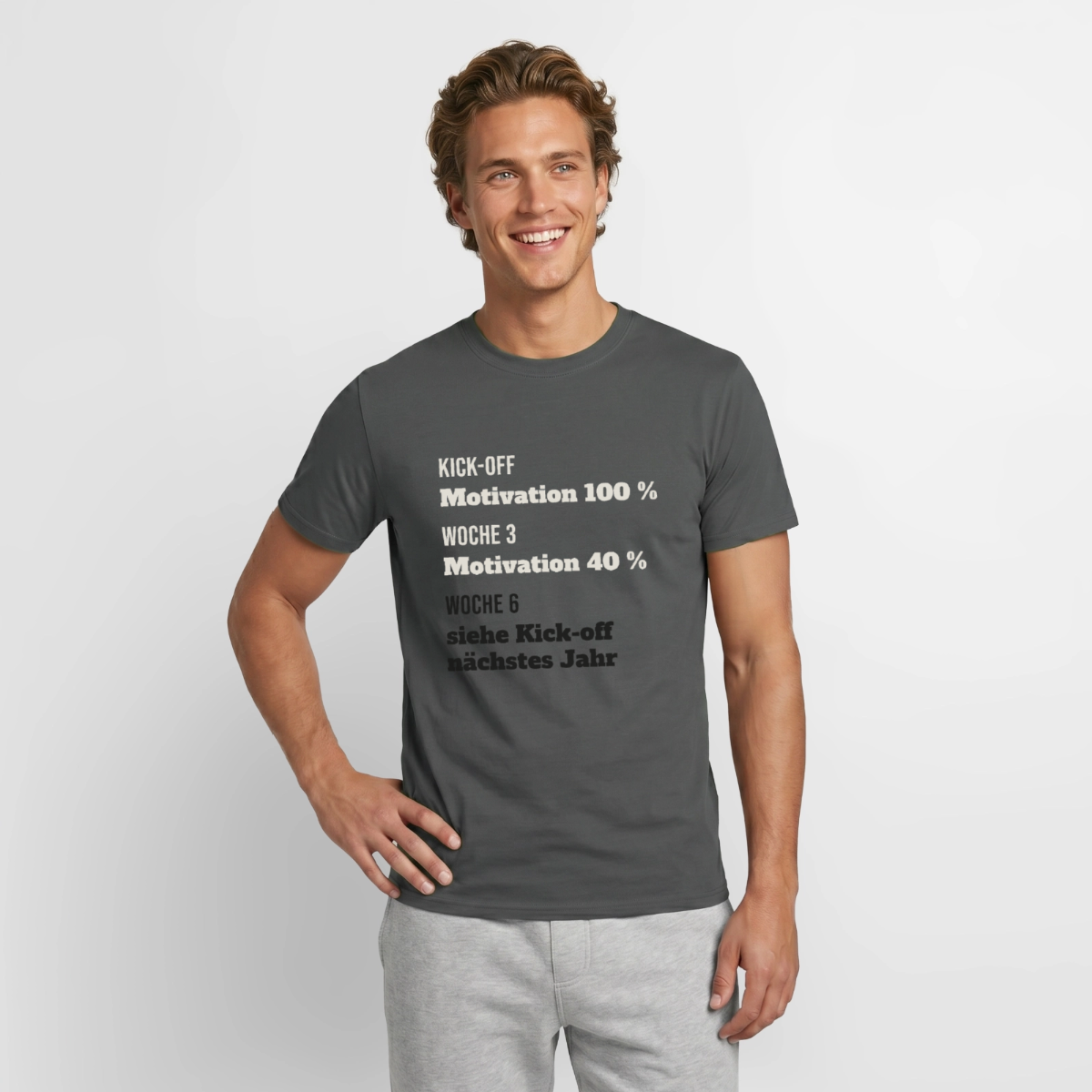 "Kick-off: Motivation 100 %. Woche 3: 40 %. Woche 6: siehe Kick-off nächstes Jahr" Motiv-T-Shirt für Männer, Farbe Anthrazit
